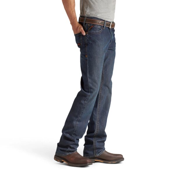 A man wearing jeans and brown boots is standing.