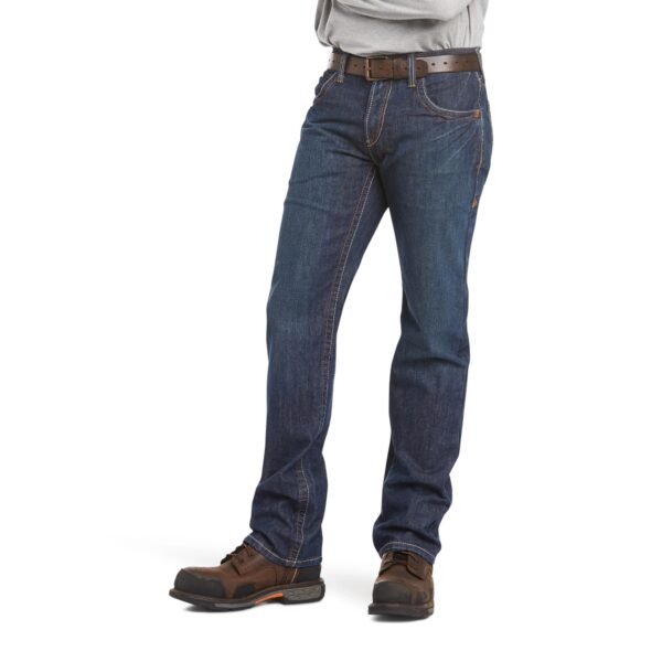 A man wearing jeans and boots is standing.