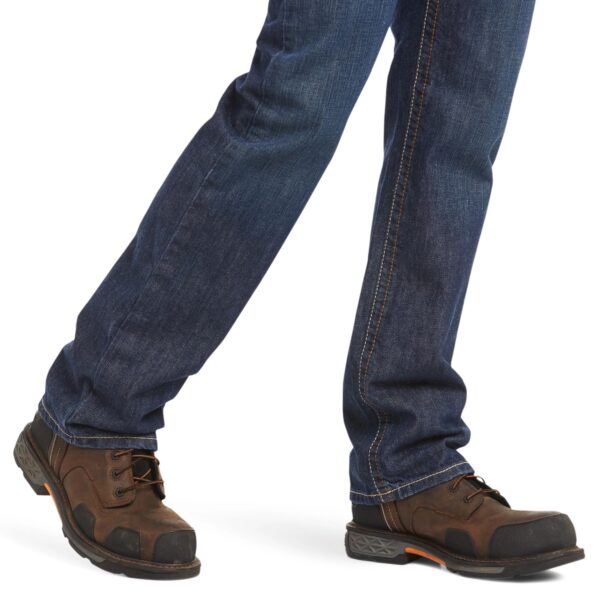 A person wearing jeans and boots is standing.