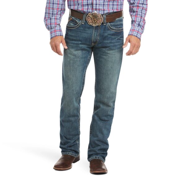 A man wearing jeans and boots is standing up.