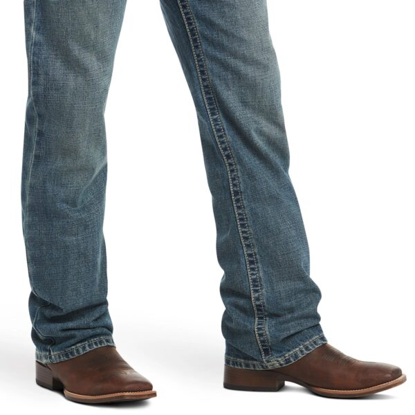 A person wearing cowboy boots and jeans.