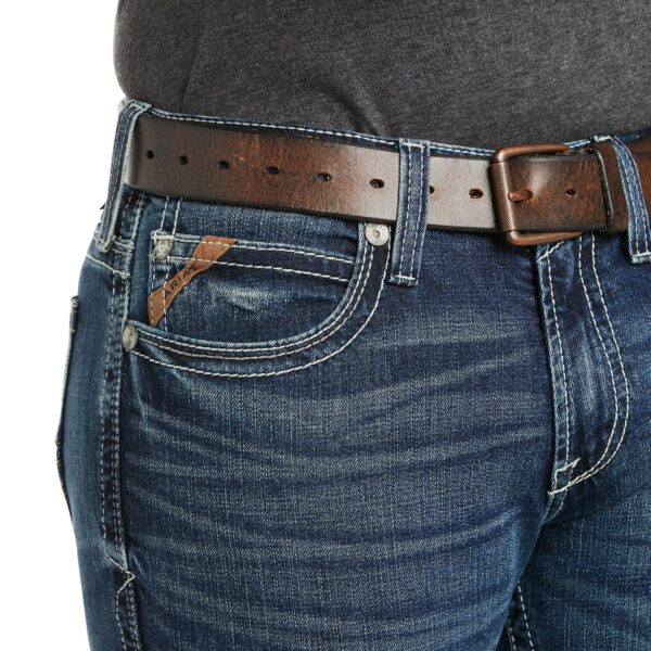 A close up of the waist and belt on someone 's jeans.