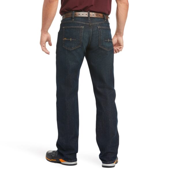 A man wearing jeans and shoes is standing up.