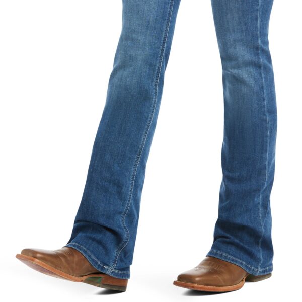 A person wearing brown shoes and jeans