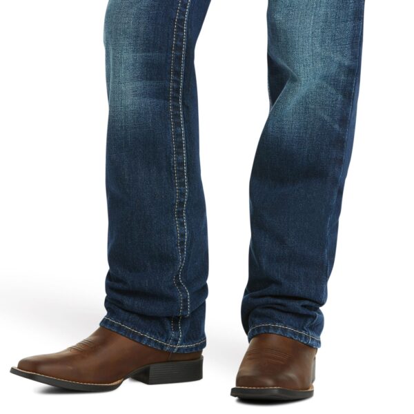 A person wearing cowboy boots and jeans.