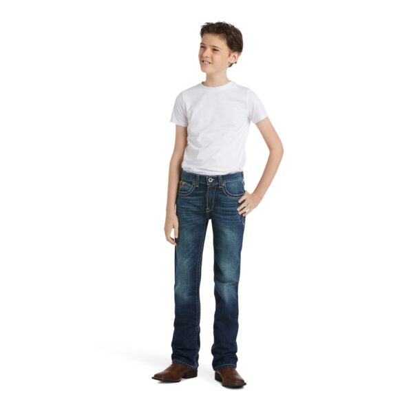A boy standing with his hands on his hips.