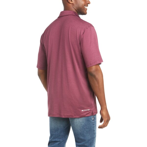 A man wearing a maroon shirt and jeans.