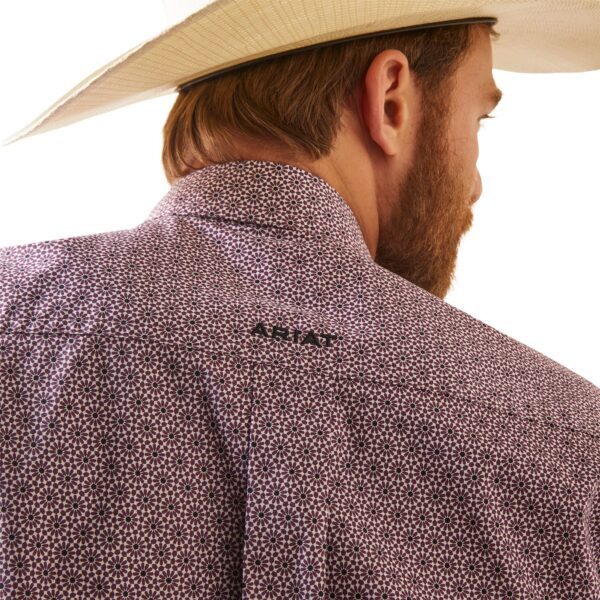 A man wearing a cowboy hat and a purple shirt.