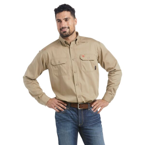 A man in jeans and a tan shirt is posing for the camera.