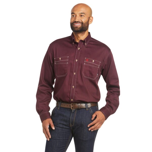 A man wearing jeans and a maroon shirt.