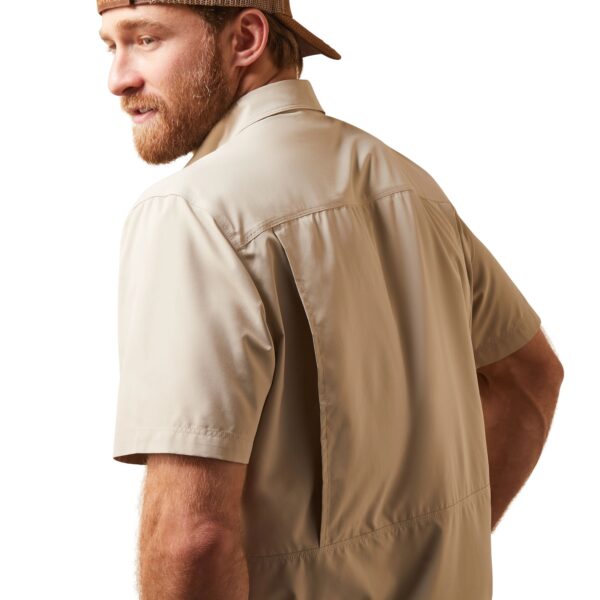 A man wearing a hat and standing in front of a white background.