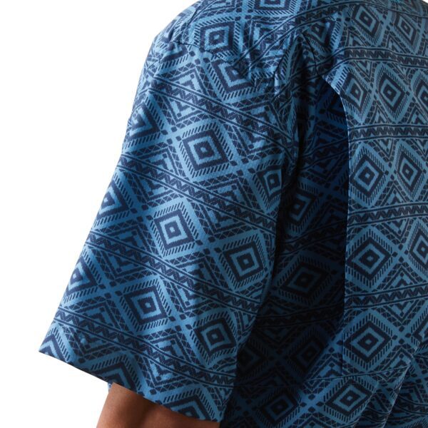 A person wearing a blue shirt with an abstract design.