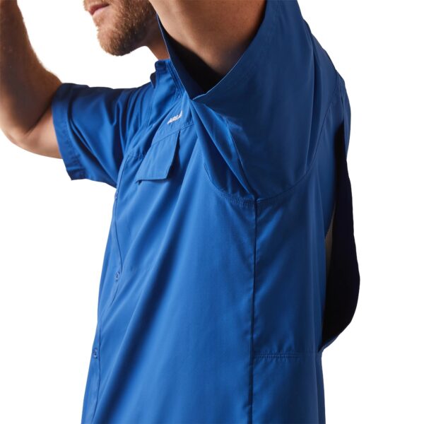 A man in blue shirt holding his hand up to the side.