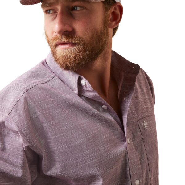 A man with beard and hat in front of white background.