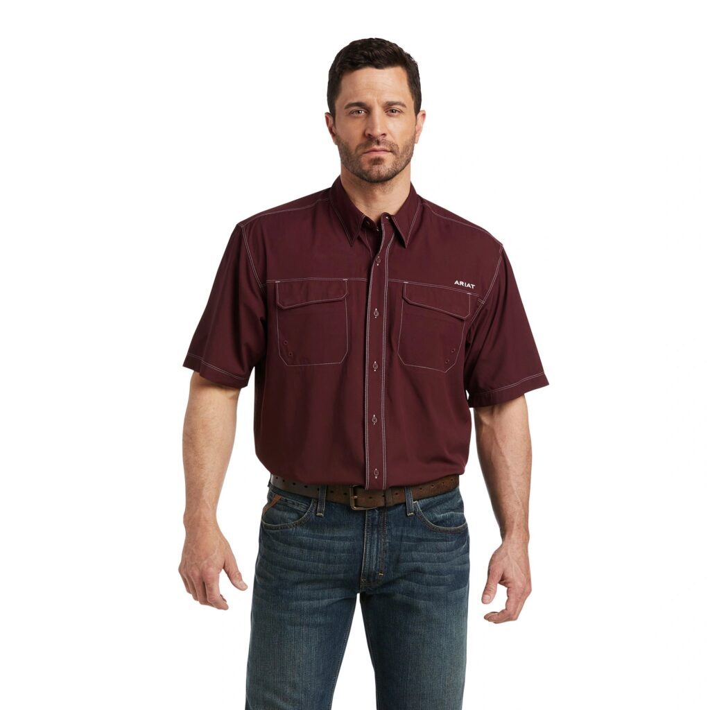 A man wearing jeans and a maroon shirt.